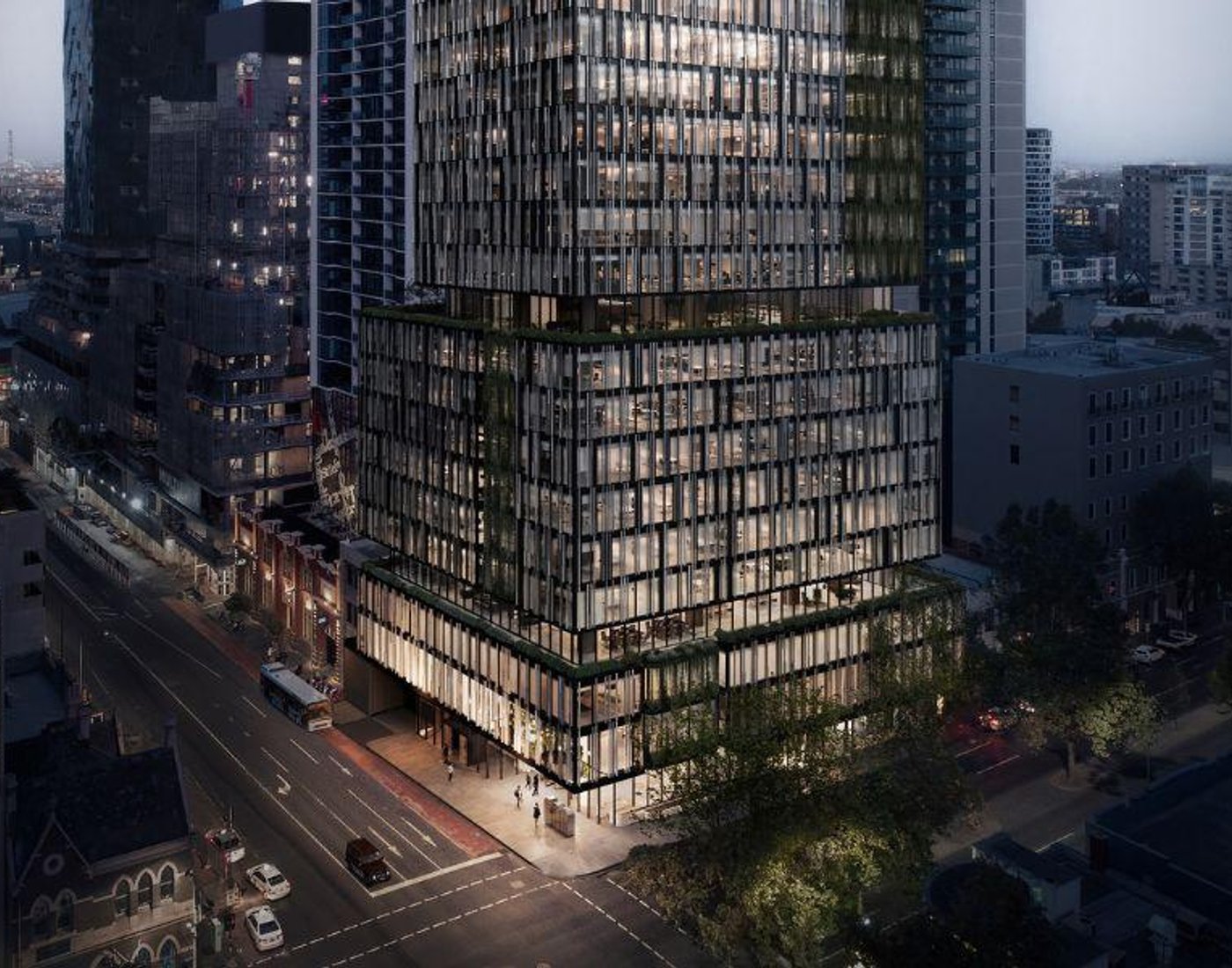 Glass office tower above a city street at dusk